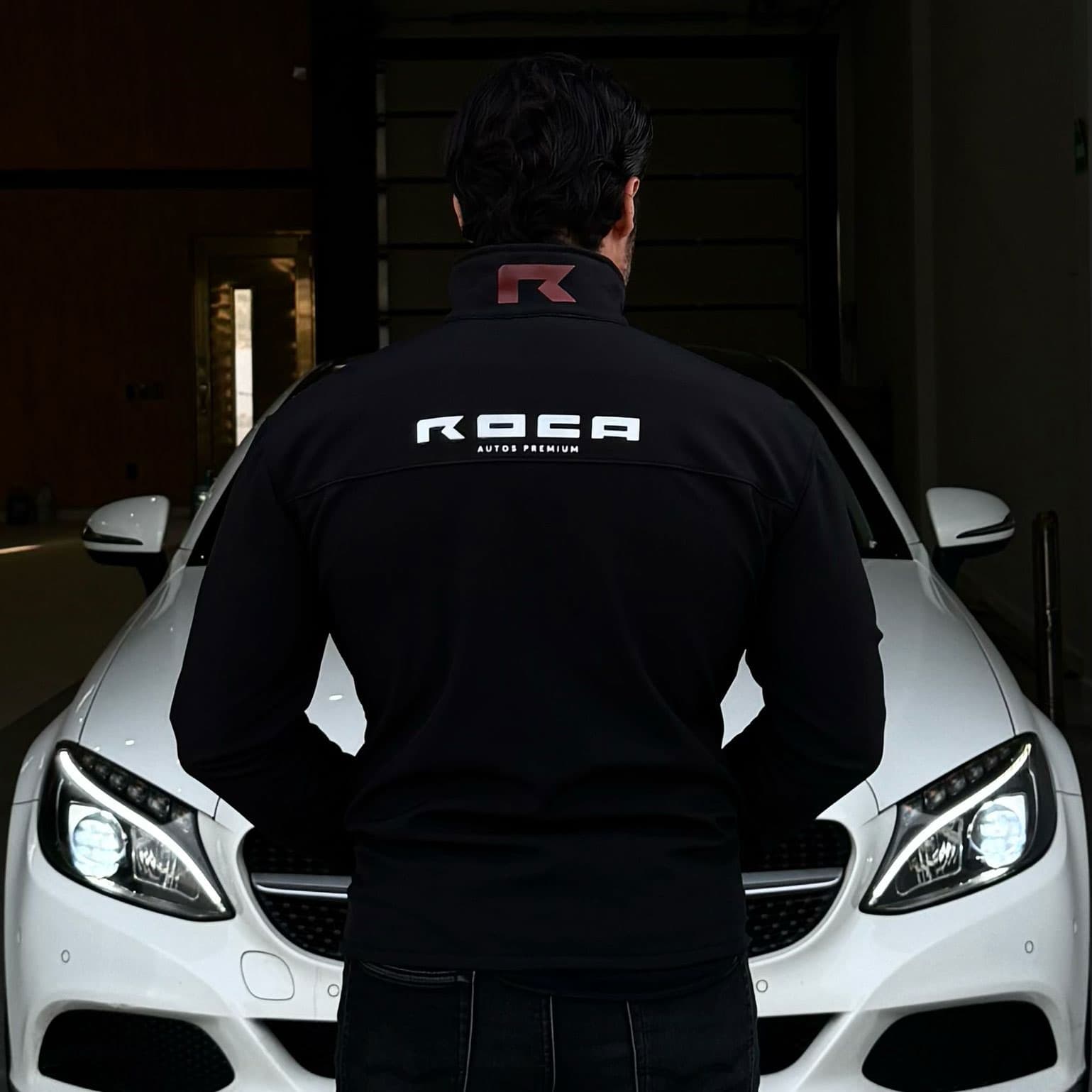 Integrante del equipo ROCA frente a un automóvil